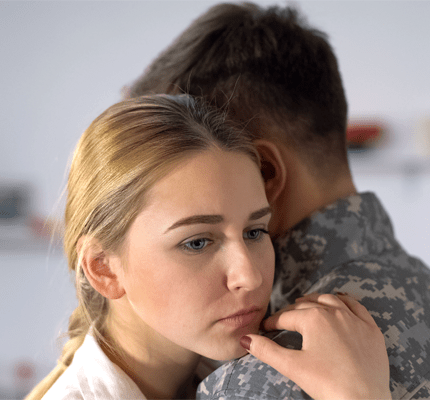 Sad girlfriend hugging male soldier