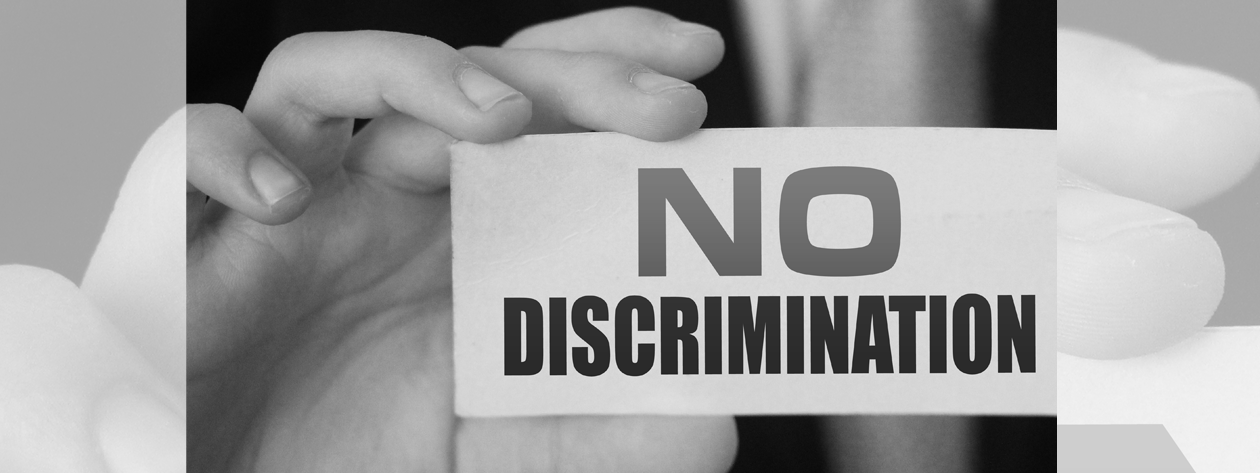 Hand holding card that reads No Discrimination