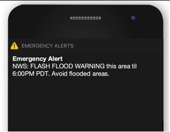 Phone screen showing a standard Wireless Emergency Alert: NWS Flash Flood Warning in this area until 6:00 PM PDT. Avoid flooded areas.