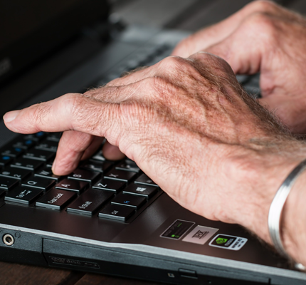 Hands typing on laptop